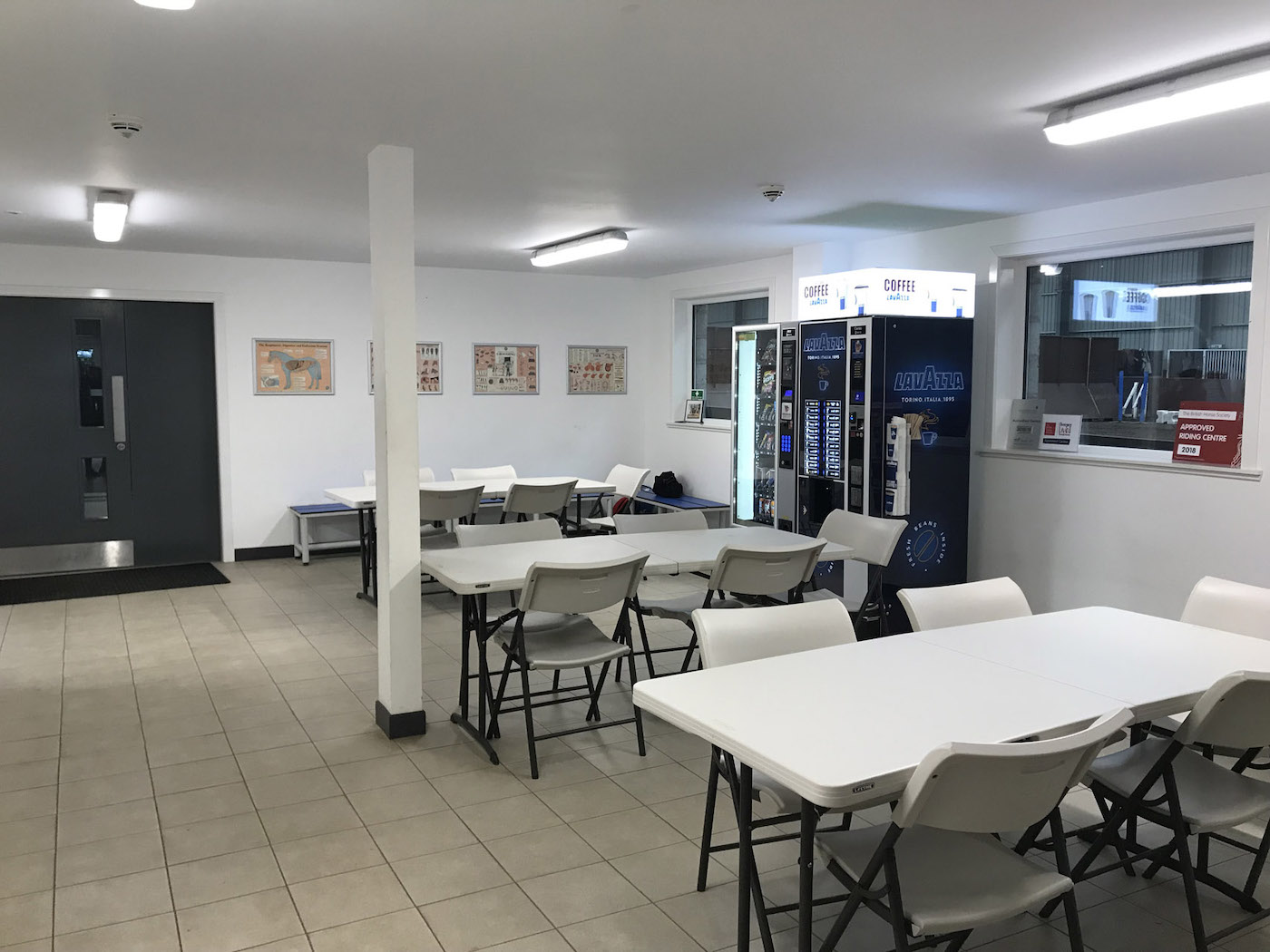 Modern break room with tables, chairs, and vending machines